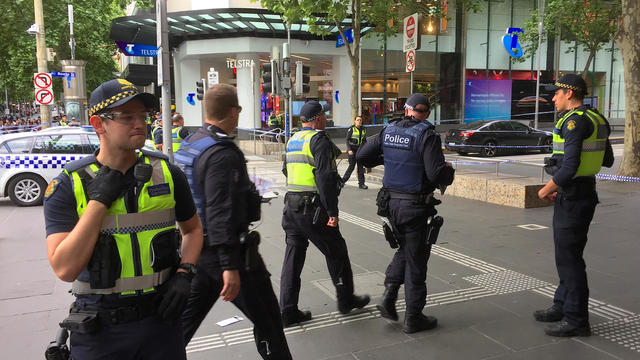 Policemen stop members of the public from walking towards the Bourke Street mall in central Melbourne 