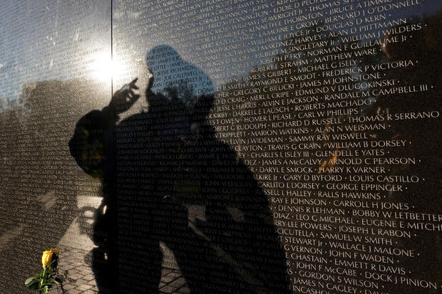 A visitor is reflected in the Vietnam Veterans Memorial wall on Veteran's Day in Washington 