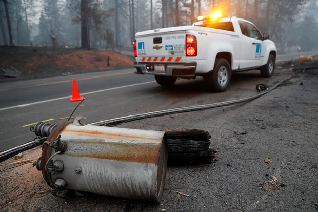 An electricity pole damaged by the Camp Fire lies near a Pacific Gas & Electric truck in Paradise 