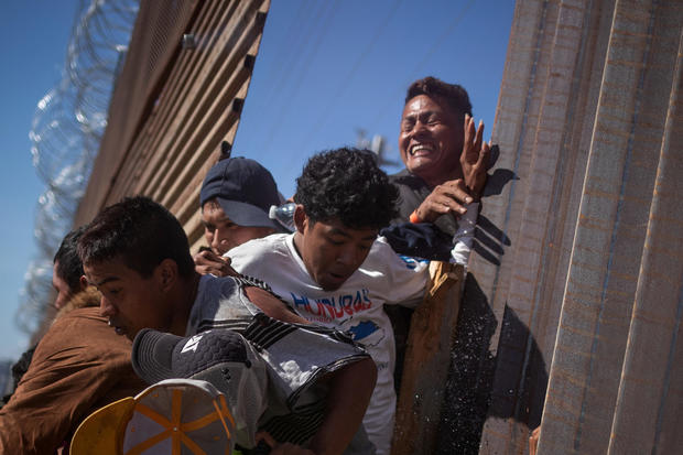Migrants are hit by tear gas after attempting to illegally cross the border wall into the U.S. in Tijuana, Mexico 