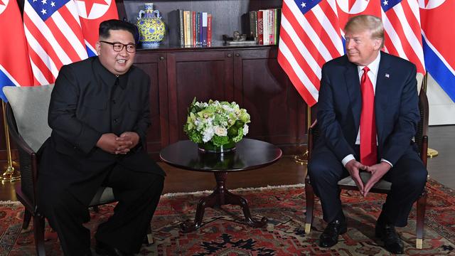 President Trump sits next to Kim Jong Un 