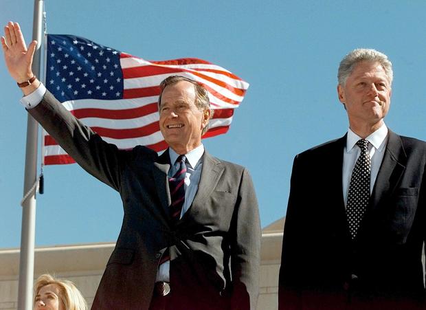 Former US President George Bush (L) waves 