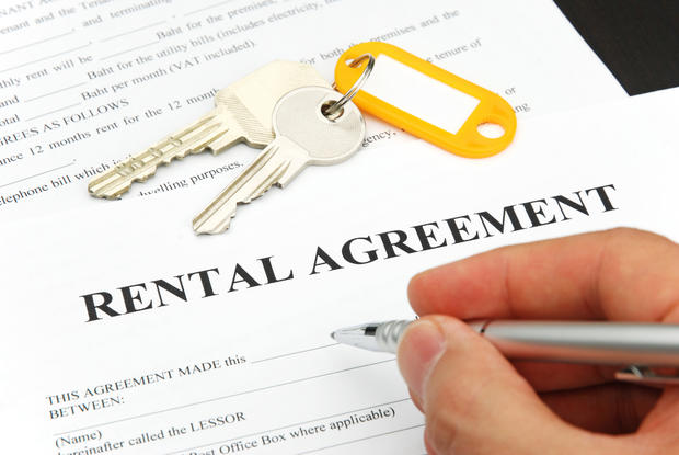 Person signing a rental agreement form with a pen lease apartment rent for rent 