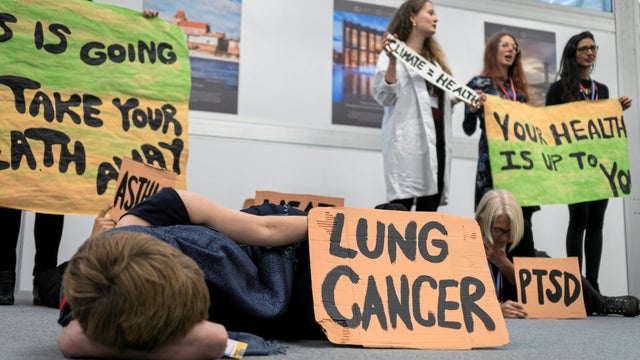 Environmental activists hold placards during a "Climate Is Health" protest during the COP24 U.N. Climate Change Conference 2018 in Katowice 
