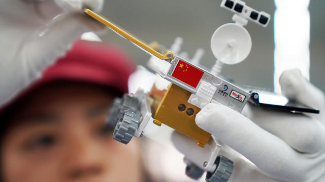 Worker inspects a scale model of the moon rover for China's Chang'e 4 lunar probe, at a factory in Dongguan 