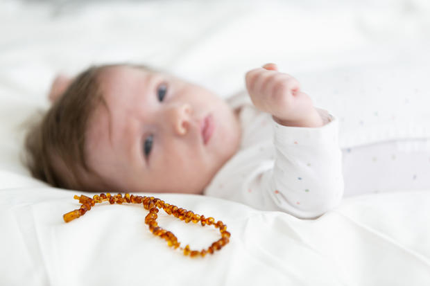 3 month old  beautiful, cute baby with amber necklace 