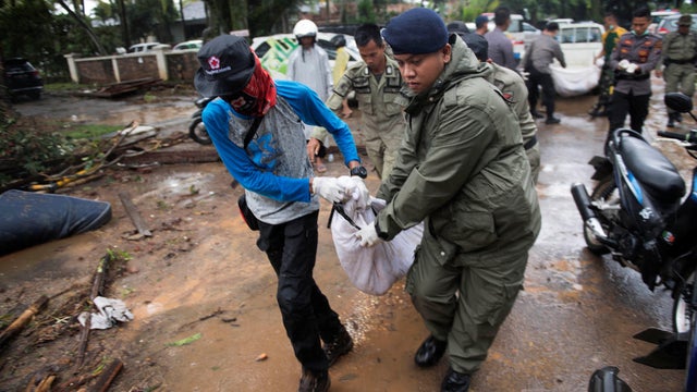 Rescue team members carry the dead body of a victim after a tsunami hit Tanjung Lesung beach in Banten 