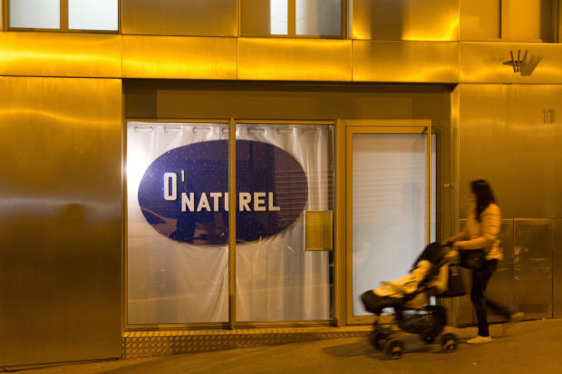 A woman pushes a stroller past the nudist restaurant O'Naturel" in Paris on Dec. 5, 2017. 