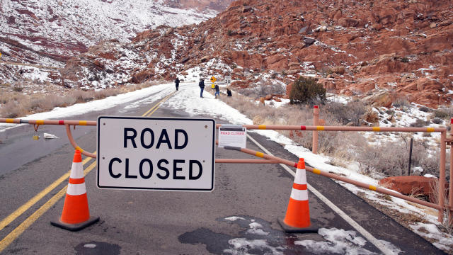 Hikers walk up the main road, which is closed because of the partial government shutdown, in Arches National Park, Utah 