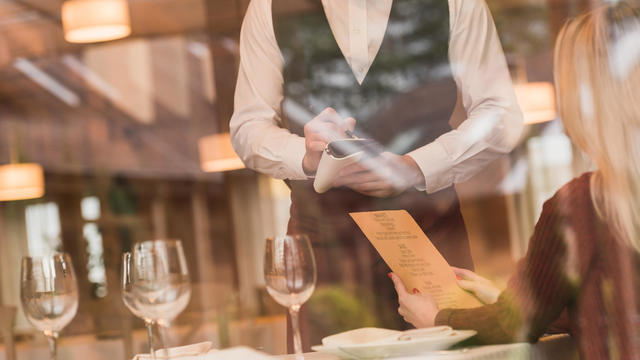 Waiter writing down the order of customer 