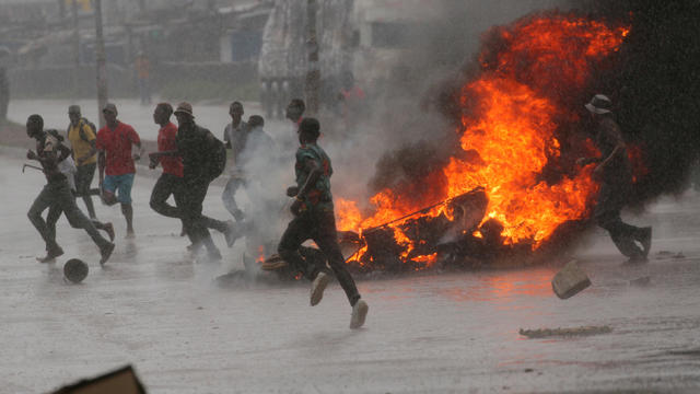 FILE PHOTO: People run at protest as barricades burn during rainfall in Harare 
