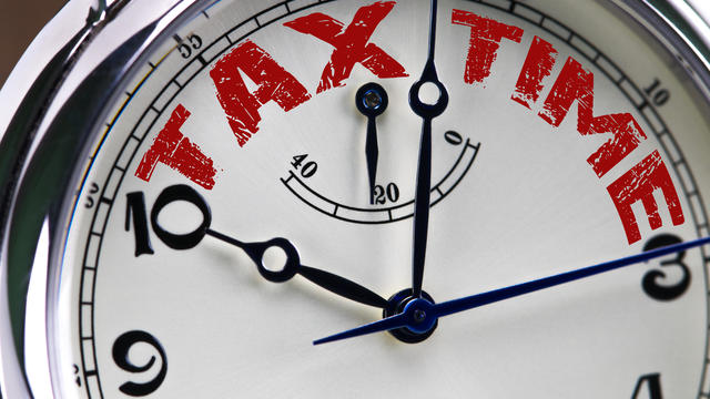 tax time concept clock closeup isolated on white background with red words 
