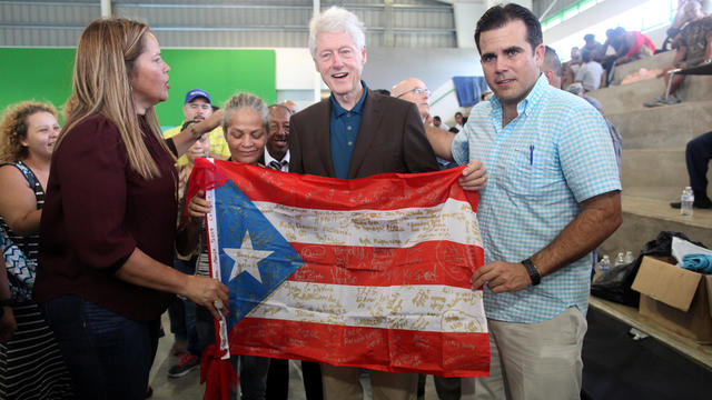 Former U.S. President Clinton, Puerto Rico Governor Rossello and Mayor of Canovanas Soto hold a Puerto Rican flag in Canovanas 