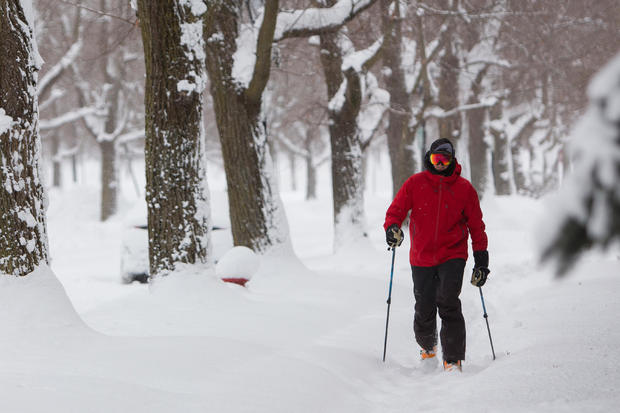 Man cross-country skis down sidewalk during a winter storm in Buffalo, New York 