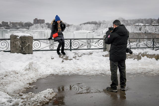 A couple takes a photo of ice formed around Niagara Falls due to subzero temperatures during a visit to Niagara Falls