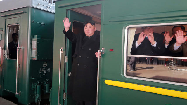 North Korean leader Kim Jong Un waves from a train as he departs for a summit in Hanoi 