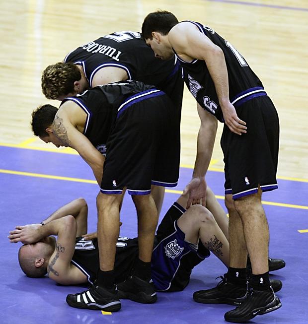 Mike Bibby (on floor) of the Sacramento Kings is l 