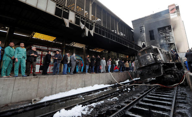 People gather at the main train station after a fire caused deaths and injuries, in Cairo 