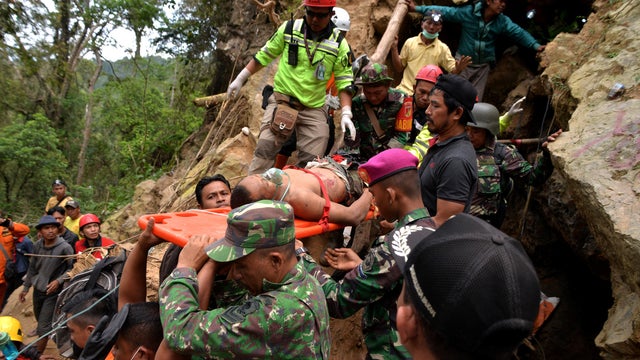 Rescue workers carry a miner who survived from the collapse of an illegal gold mine at Bolaang Mongondow regency in North Sulawesi 