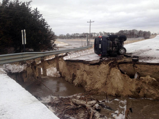 ​An overturned vehicle is seen on a washed-out road in a picture posted to a Nebraska State Patrol Twitter account on March 14, 2019. 