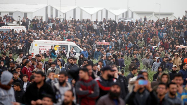 Palestinians gather during a protest marking Land Day and the first anniversary of a surge of border protests, at the Israel-Gaza border fence east of Gaza City 