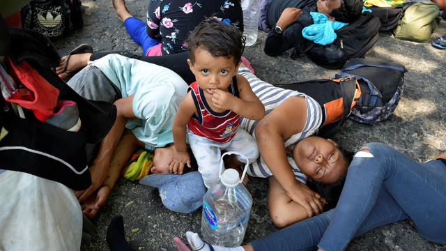 Migrants from Central America rest on the side of a highway during their journey towards the United States, in Escuintla 