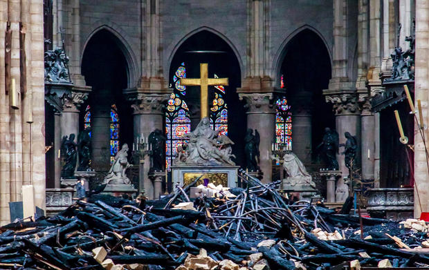 The cross and sculpture of Pieta by Nicolas Coustou are seen surrounded by debris inside Notre Dame Cathedral in the aftermath of a fire that devastated the church during a visit by French Interior Minister Christophe Castaner, not pictured, in Paris, Fra 