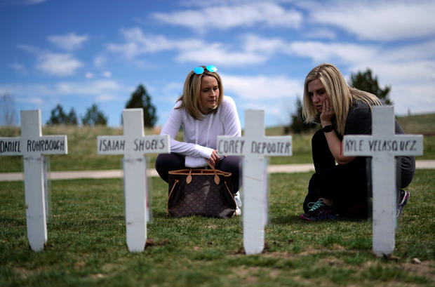 Jennifer Dunsmore (L) and Cassanda Sadusky look at a line of crosses commemorating those killed in the Columbine High School shooting on the 20th anniversary of the attack in Littleton 