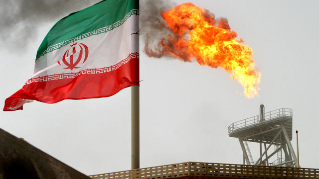 FILE PHOTO: A gas flare on an oil production platform in the Soroush oil fields is seen alongside an Iranian flag in the Persian Gulf 