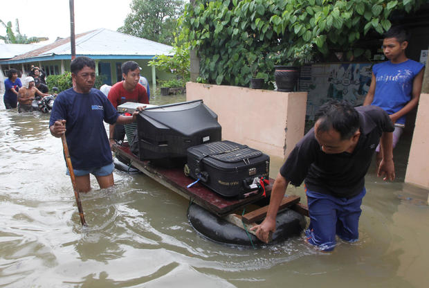 Residents carry their belongings with a raft through the flood in Bengkulu 