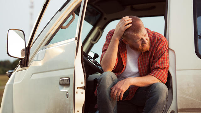 Driver of the car is sitting thinking 