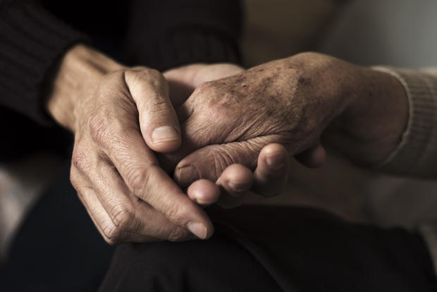 young man holding the hand of an old woman aging elderly senior citizen 