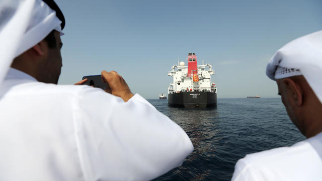 Port officials take a photo of a damaged Andrea Victory ship at the Port of Fujairah 