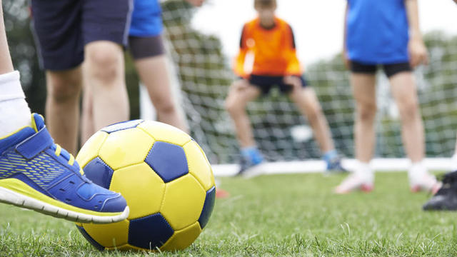 Close Up Of Children's Feet In Soccer Match 