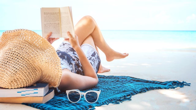 Woman  reading a book on the beach in free time summer holiday 