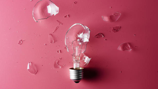 Creative crisis. Broken light bulb on a pink background. The concept of lack of ideas and inspiration. 