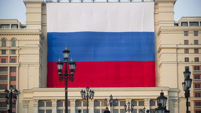 A man stands in front of a giant Russian 