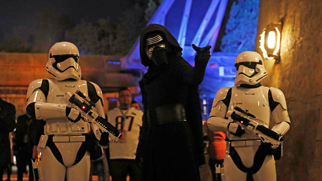 People dressed as stormtroopers and the character Kylo Ren react at "Star Wars: Galaxy's Edge" at Disneyland Park in Anaheim 