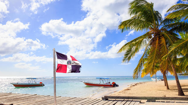 Caribbean beach and Dominican Republic flag 