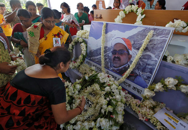 People pay homage in front of a portrait of Dipankar Ghosh, a 52-year-old Indian photographer who scaled the world's fifth-highest peak, the snow-capped Mount Makalu, before his funeral in Howrah 