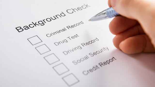 Person Hand Filling Background Check Form 
