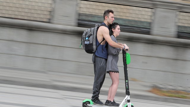 A couple rides a Lime S Electric scooter near the White House in Washington 