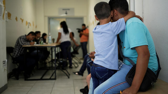 A man and his son from El Salvador wait for a turn to apply for U.S. asylum at the premises of the state migrant assistance office in Ciudad Juarez 
