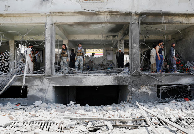 Afghan security forces inspect a damaged building at the site of a blast in Kabul, Afghanistan 