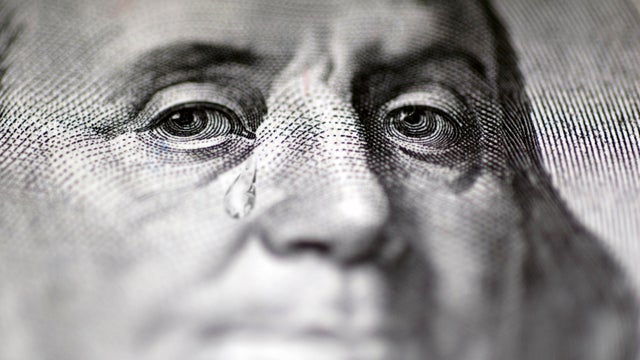 Tear falling from face on US dollar bill, close-up 