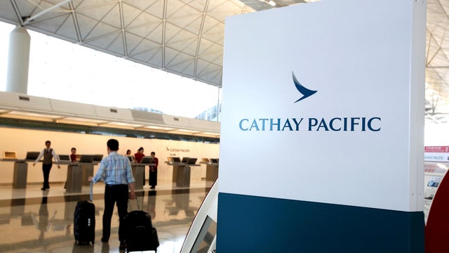 A passenger walks to the First Class counter of Cathay Pacific Airways at Hong Kong Airport in Hong Kong 