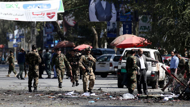 Afghan security forces remove the remains of bodies from the site of a blast in Kabul 