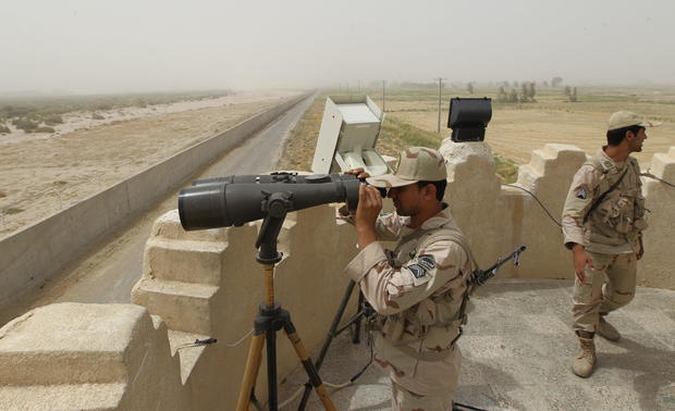An Iranian border guard looks through a 