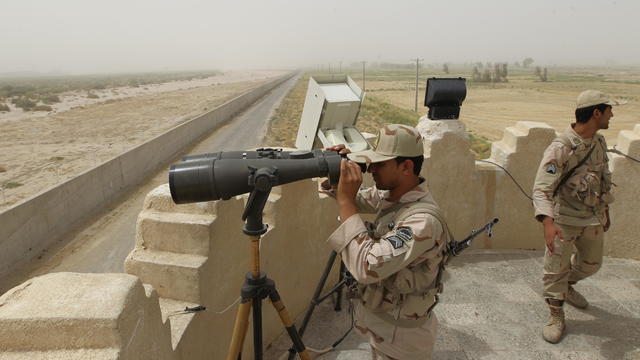 An Iranian border guard looks through a 