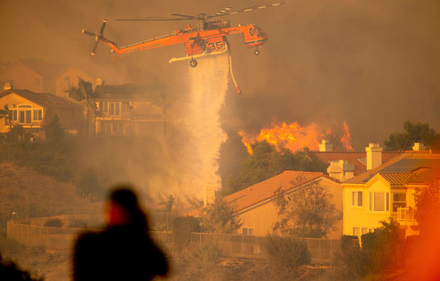 A helicopter drops water to help fight the Saddle Ridge Fire in the Porter Ranch section of Los Angeles, California, on October 11, 2019. 